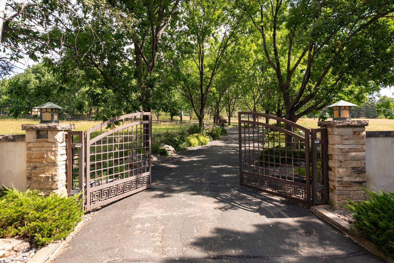 Gated stone entry and tree-lined drive